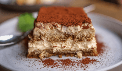 Easy Tiramisu: No-Bake Italian Dessert in Simple Steps 72 Delicious tiramisu dessert with creamy layers and a dusting of cocoa powder on a white plate and ladyfingers