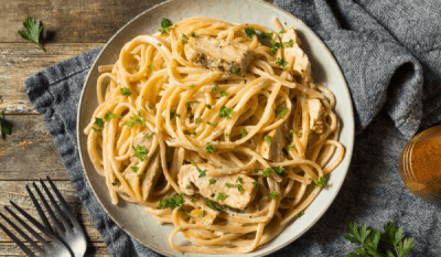 Cheesecake Factory Louisiana Chicken Pasta (Copycat Recipe) - Easy Dinner 36 Louisiana-style chicken pasta on a rustic plate, featuring a creamy Cajun sauce, tender chicken, and perfectly cooked linguine, garnished with fresh herbs.
